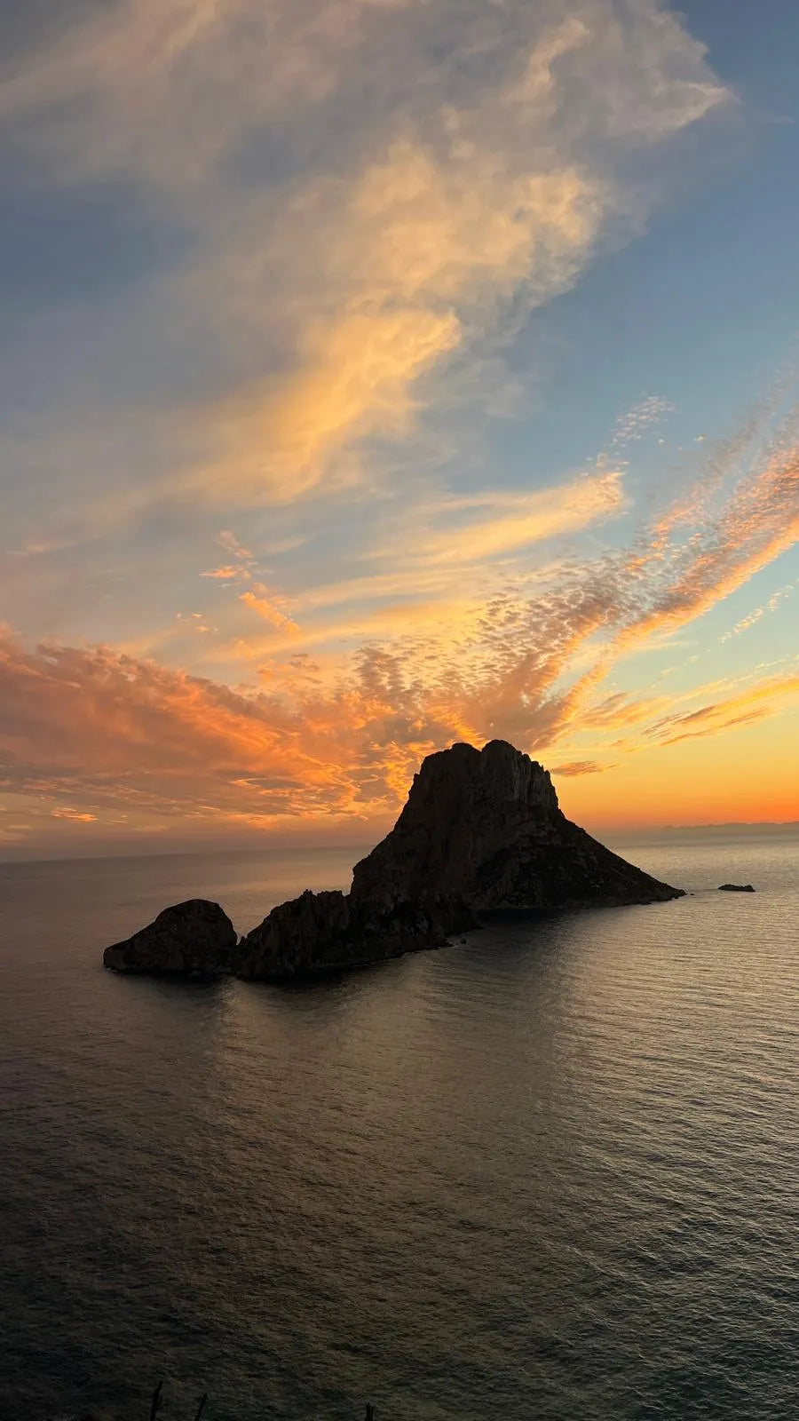 Island in the ocean with a colorful sunset sky