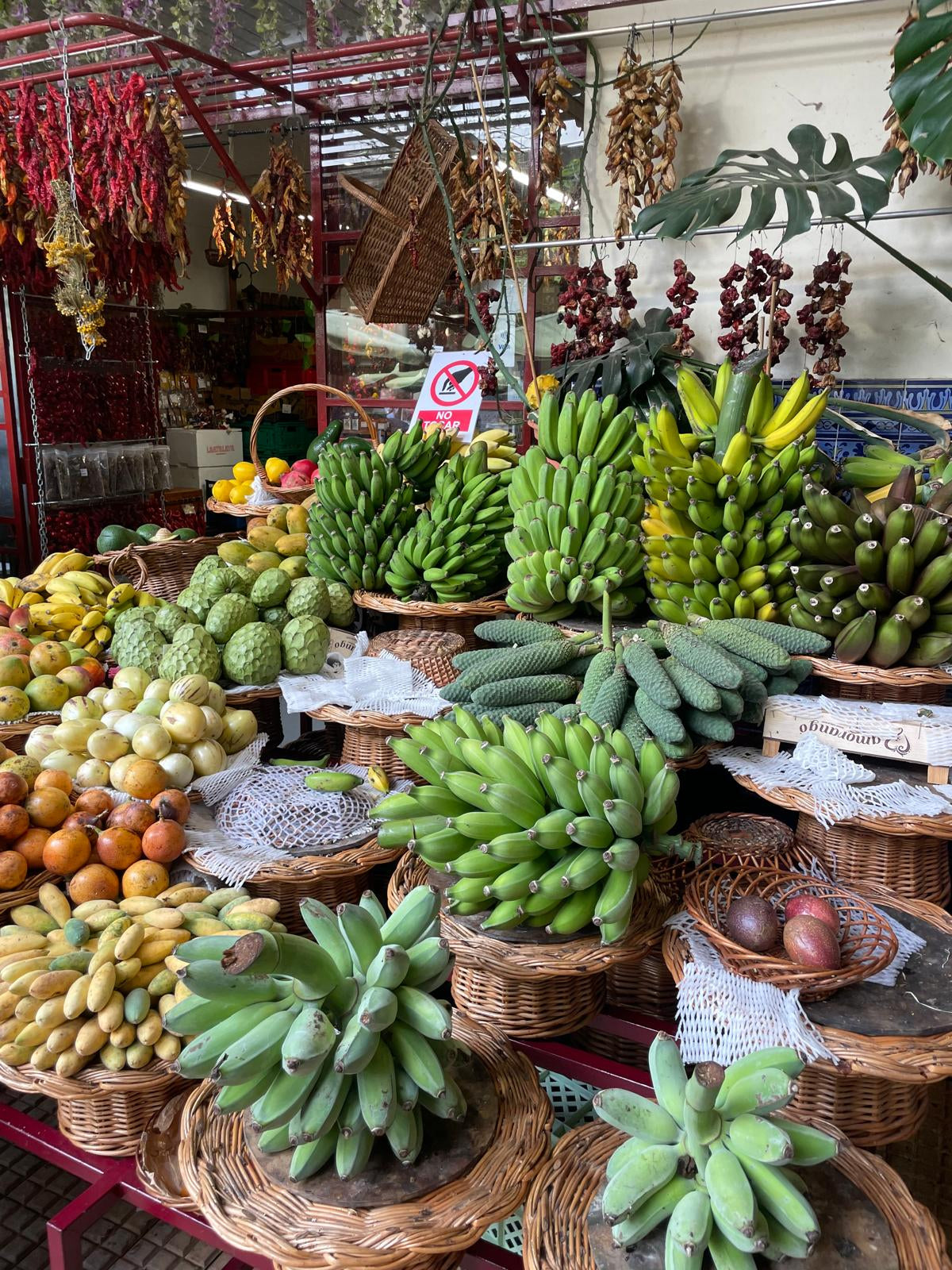 Display of various fruits including bananas and apples in a market setting.