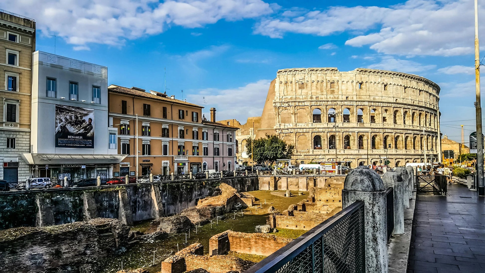 Colosseum in Rome with modern buildings and street in the foreground