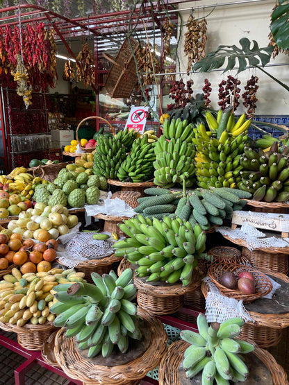 Display of various fruits including bananas and apples in a market setting.