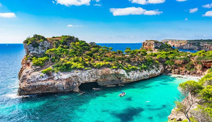 Scenic view of a rocky island with clear blue water and a blue sky.