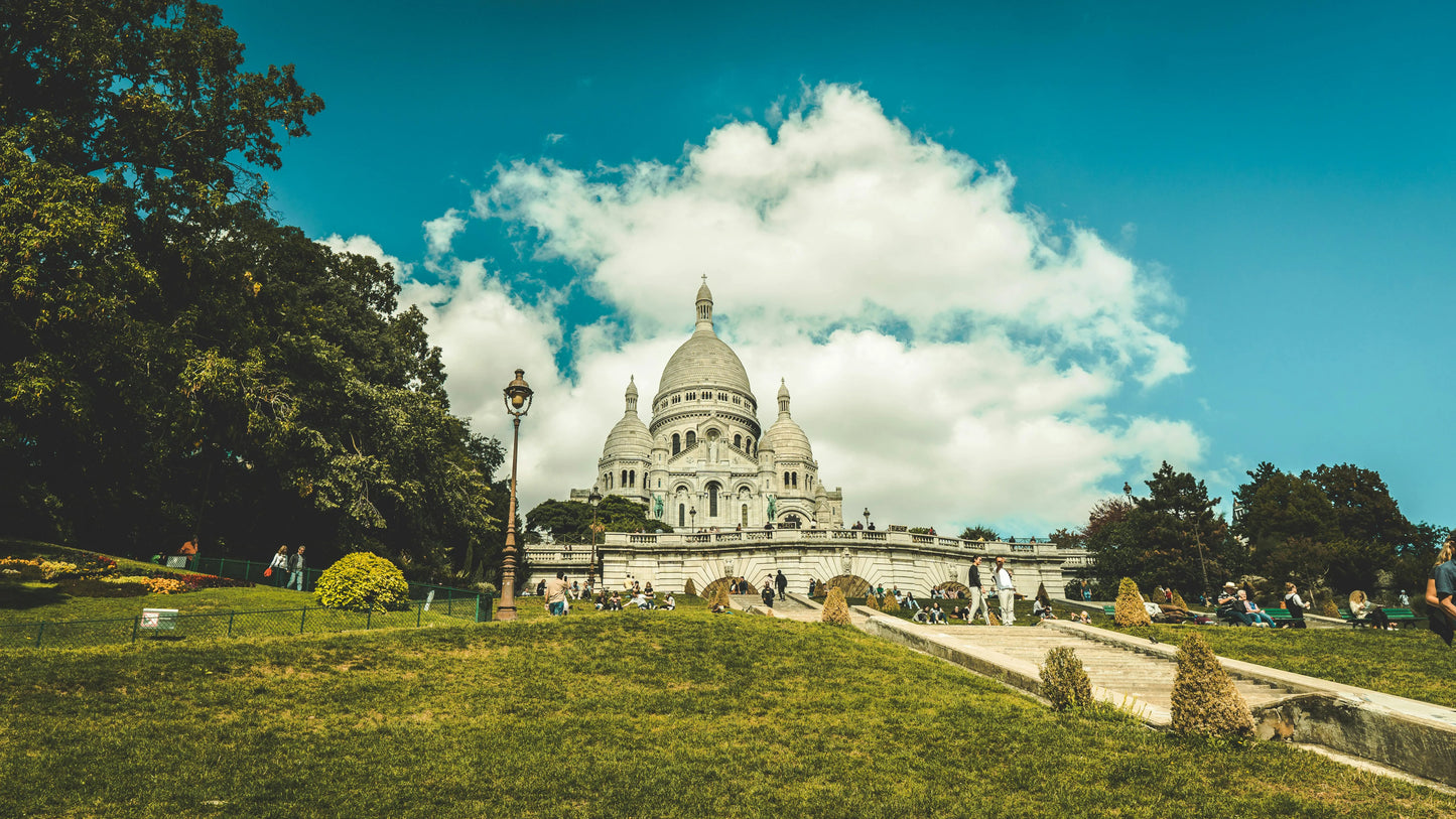 Basilica of the Sacré-Cœur in Montmartre with green grass and trees