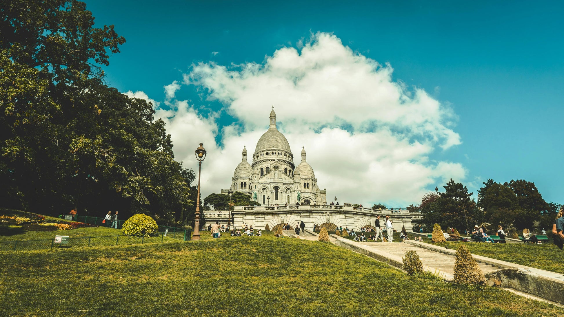 Basilica of the Sacré-Cœur in Montmartre with green grass and trees