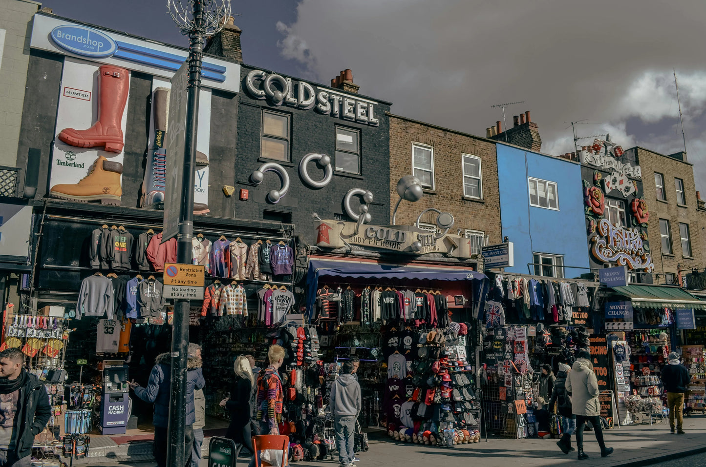 Street scene with a clothing store named 'Cold Steel' and people walking by.