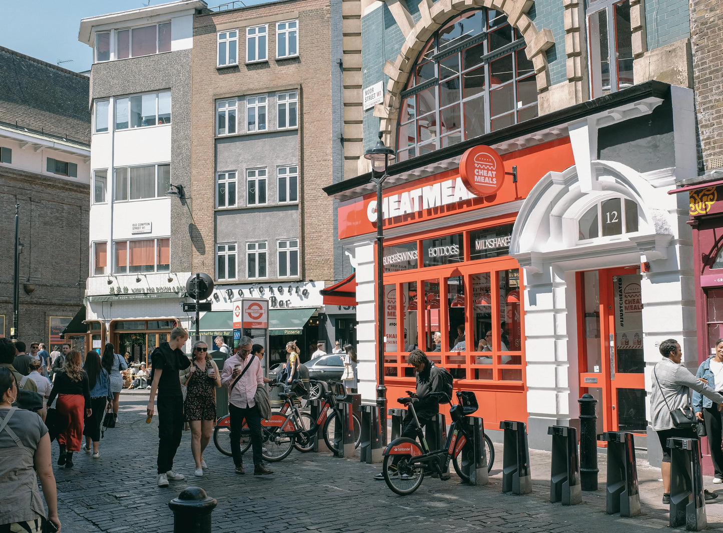 Street scene with people, bicycles, and a prominent red building with 'Gentleman' sign.