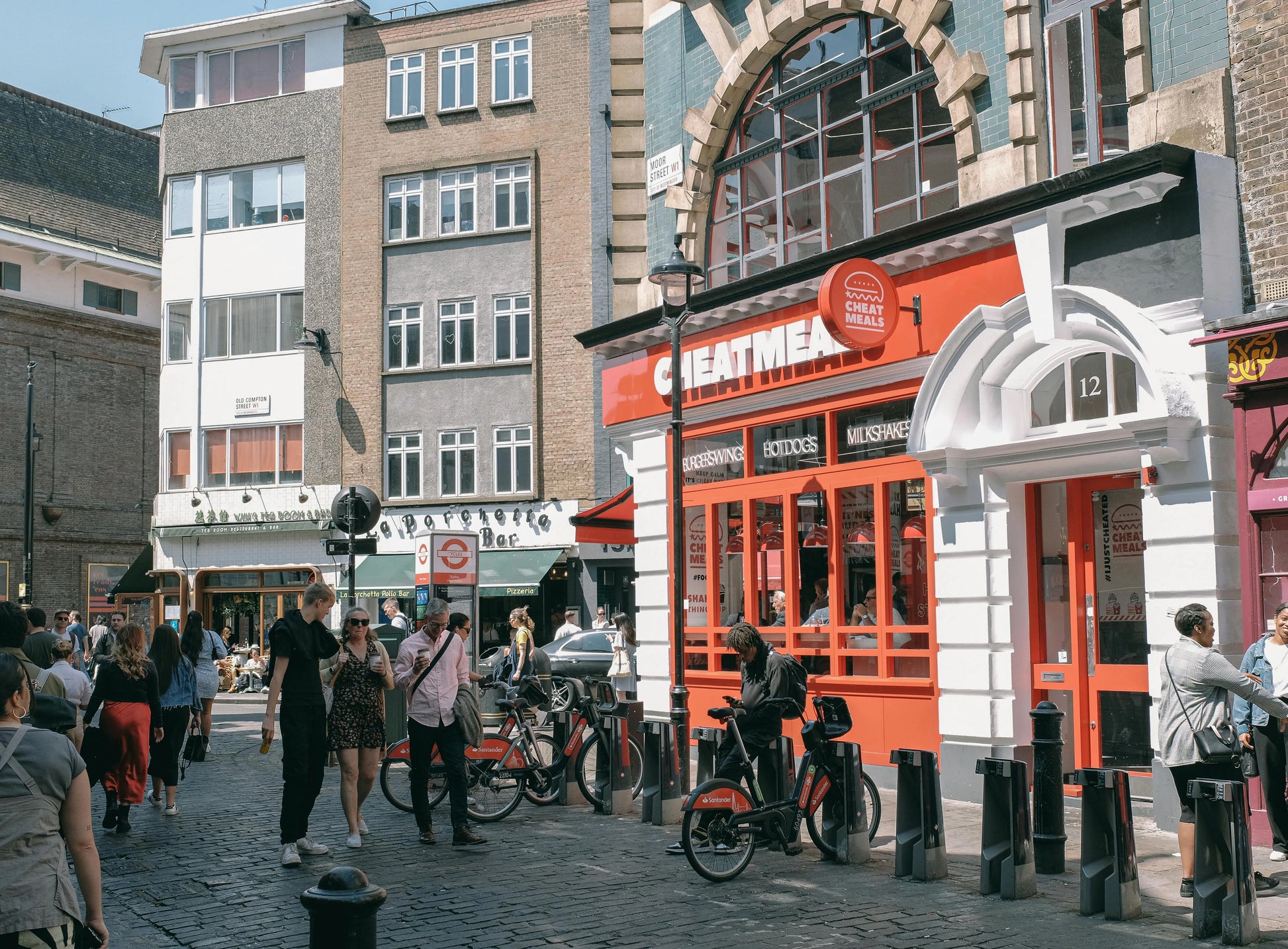 Street scene with people, bicycles, and a prominent red building with 'Gentleman' sign.