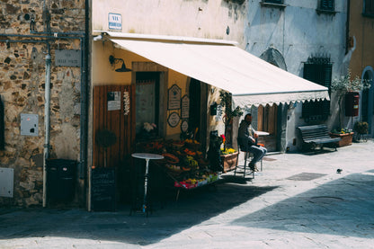Street scene with a small shop and outdoor seating area in an urban setting