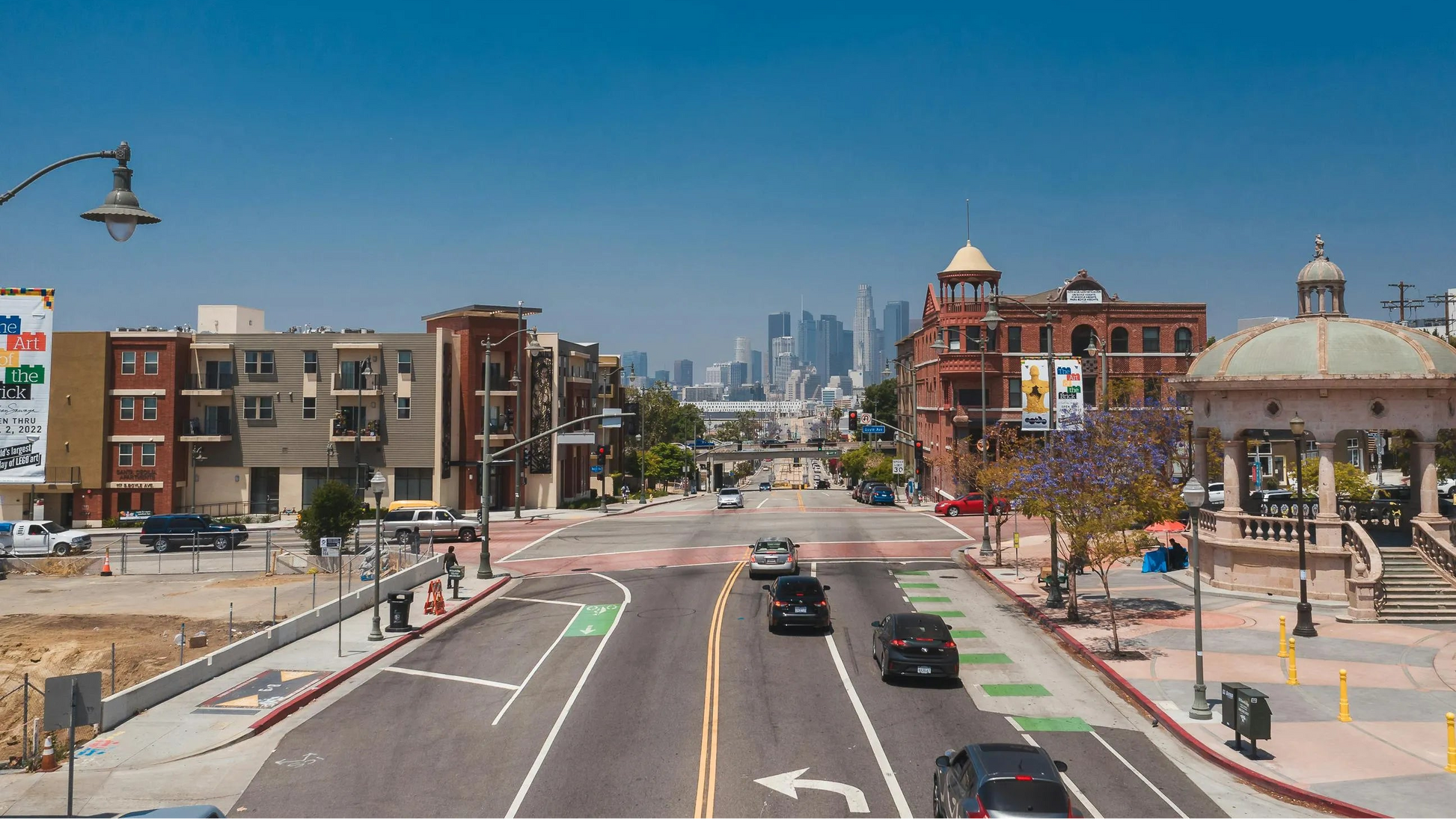 City street with buildings, cars, and a clear blue sky