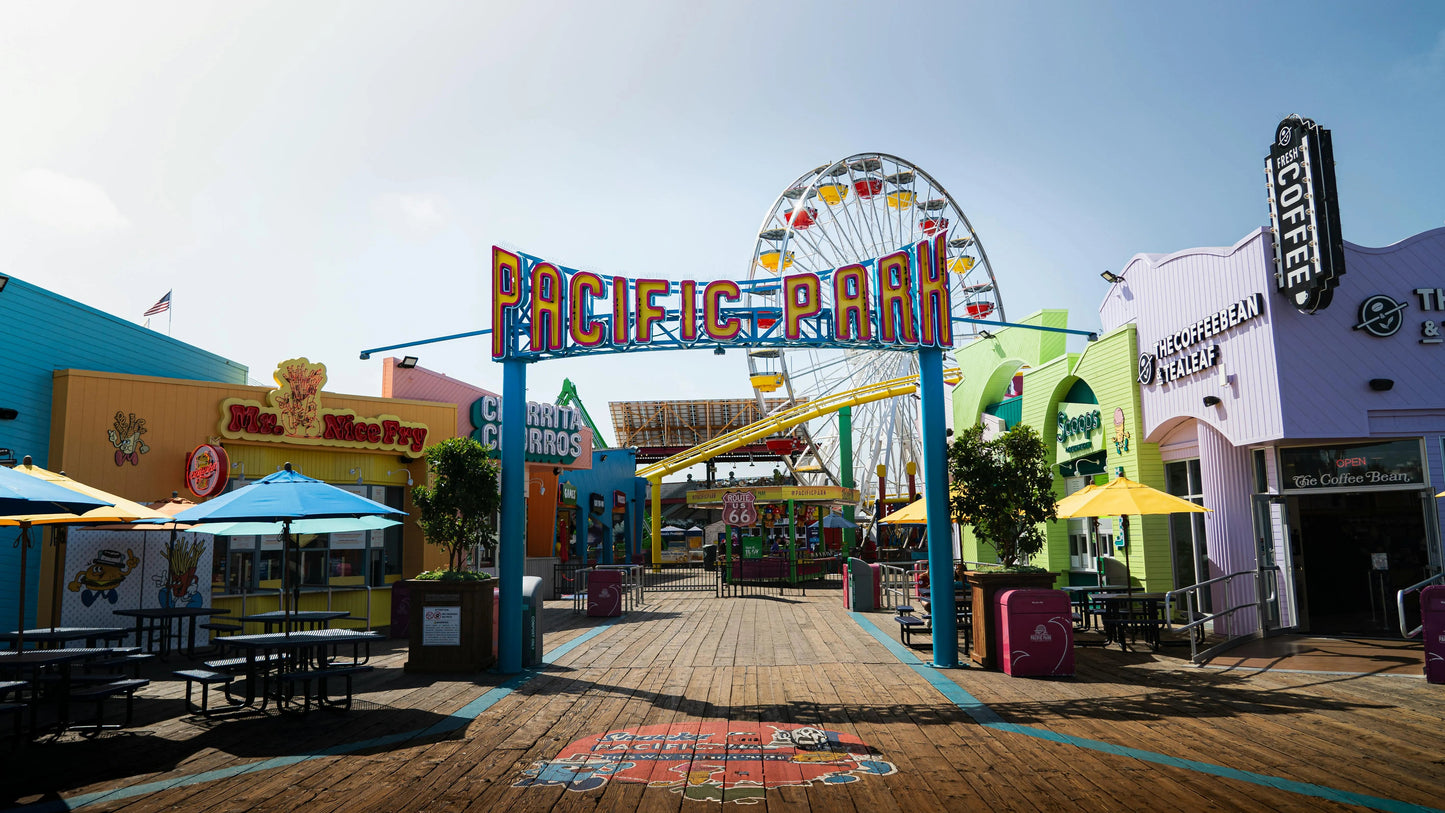 Colorful entrance to Pacific Park amusement park with Ferris wheel and various attractions.
