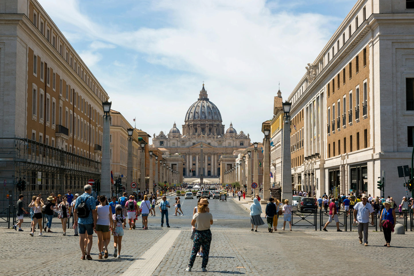 Street scene in Rome with people walking towards St. Peter's Basilica